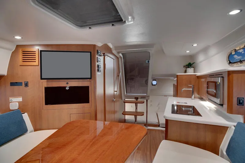 Slide: The Image of Manufacturer Provided Image: 2025 Pursuit OS 355 Offshore cabin interior with modern seating and wooden finishes. - 47