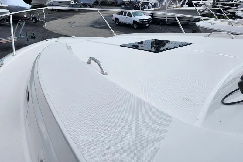 Slide: The Image of 2026 Pursuit OS 355 Offshore boat roof with speakers and rod holder against cloudy sky. - 6