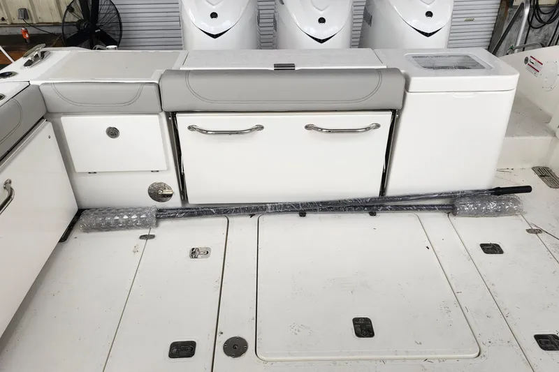 Slide: The Image of 2026 Pursuit OS 355 Offshore boat deck with railing and hatch, parked in marina. - 9