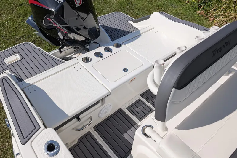 Slide: The Image of 2026 Bayliner Trophy T20CC boat deck with motor, featuring seating and rod holders. - 7