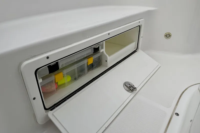 Slide: The Image of Storage compartment on 2022 Sea Hunt BX 22 BR boat, featuring organized tackle boxes. - 12