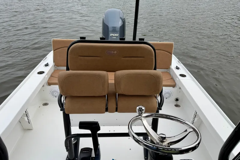 Slide: The Image of 2022 Sea Hunt BX 22 BR boat interior with steering wheel and seating, on water. - 15