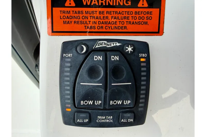 Slide: The Image of Trim tab control panel on 2022 Sea Hunt BX 22 BR boat with warning label. - 37