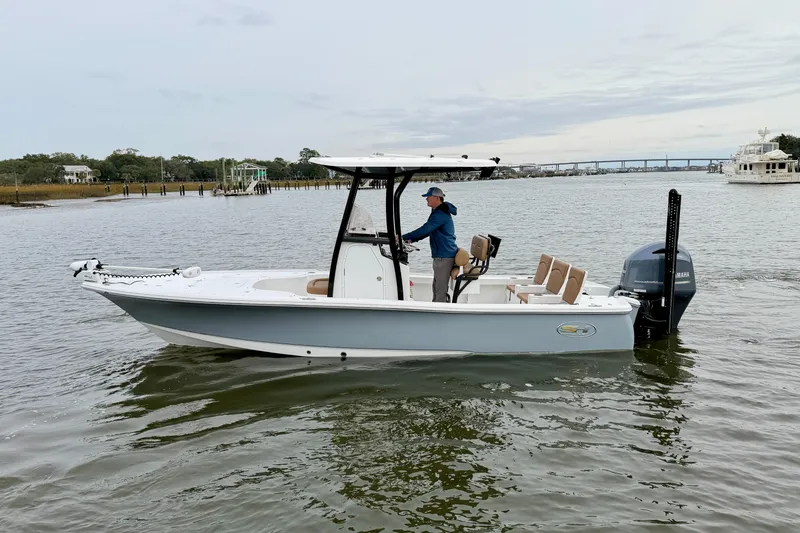Slide: The Image of 2022 Sea Hunt BX 22 BR boat on calm water, with a person steering. - 4