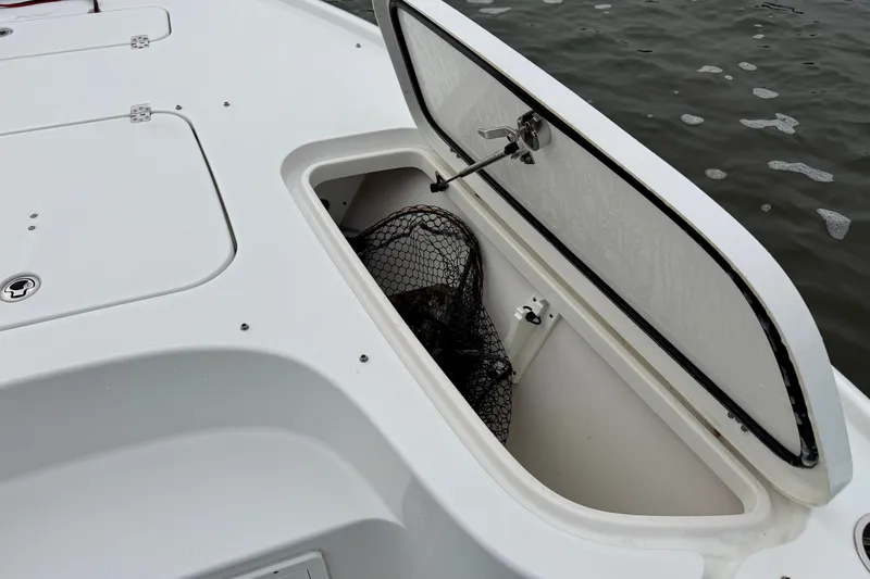 Slide: The Image of Open storage compartment on 2022 Sea Hunt BX 22 BR boat with fishing net inside. - 9