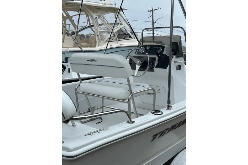 Slide: The Image of 2007 Triumph 170 CC boat with outboard motor and canopy, docked at marina. - 5