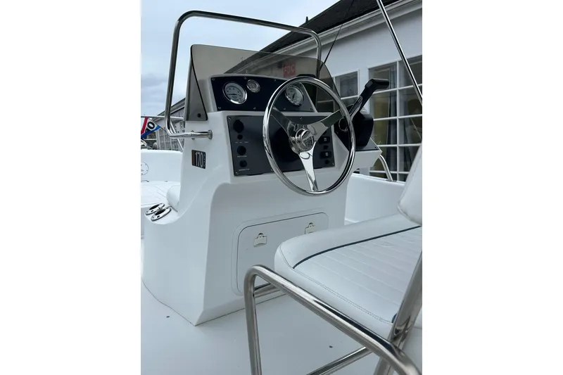 Slide: The Image of 2007 Triumph 170 CC boat interior with white seating and steering console. - 7