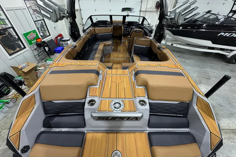 Slide: The Image of 2026 Supra SA boat interior with tan and gray seating, wood accents, and modern design. - 11