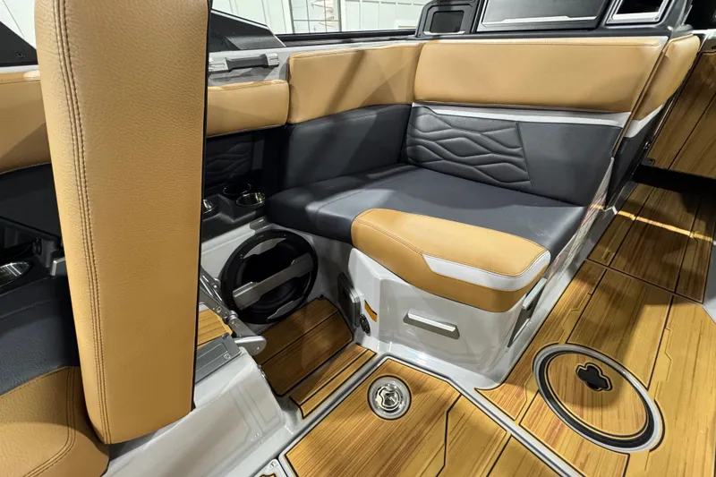 Slide: The Image of 2026 Supra SA boat interior with tan and black seating, wood flooring, and cup holders. - 15