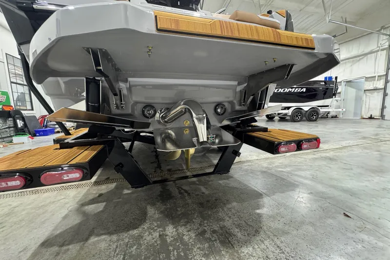 Slide: The Image of 2026 Supra SA boat rear view in a garage, showcasing propeller and swim platform. - 6