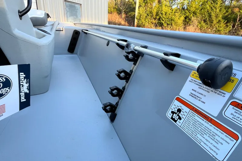 Slide: The Image of 2026 Tracker Bass Tracker Classic CC interior with rod holders and safety labels. - 70