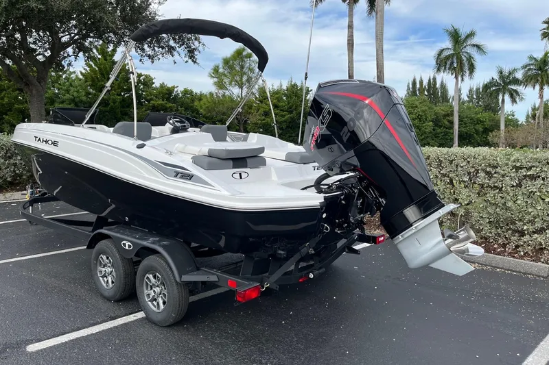 Slide: The Image of 2026 Tahoe T21 boat on trailer with powerful outboard motor, parked near palm trees. - 100