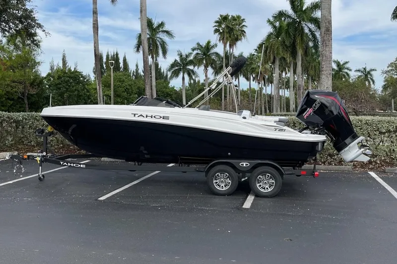 Slide: The Image of 2026 Tahoe T21 boat on trailer, parked with palm trees in the background. - 97
