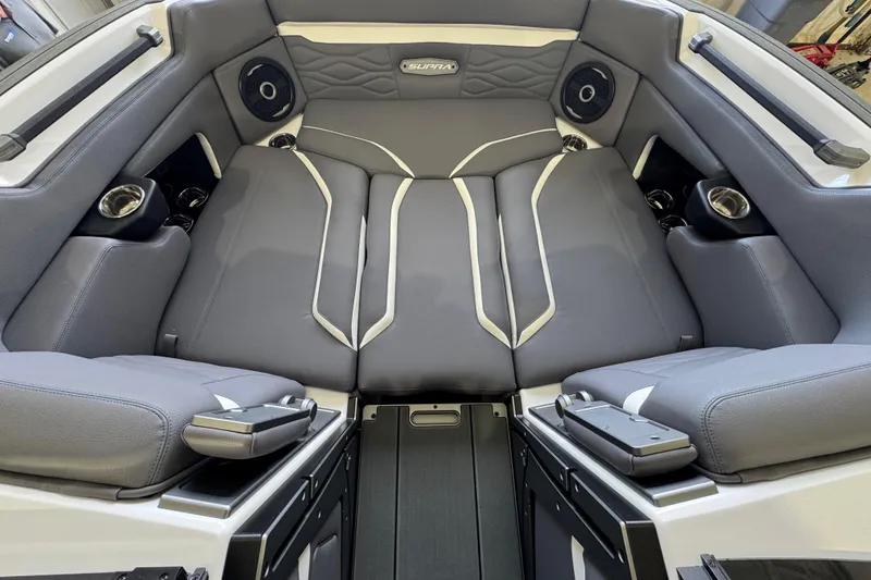 Slide: The Image of 2026 Supra SE boat interior with gray seating, cup holders, and speakers. - 14