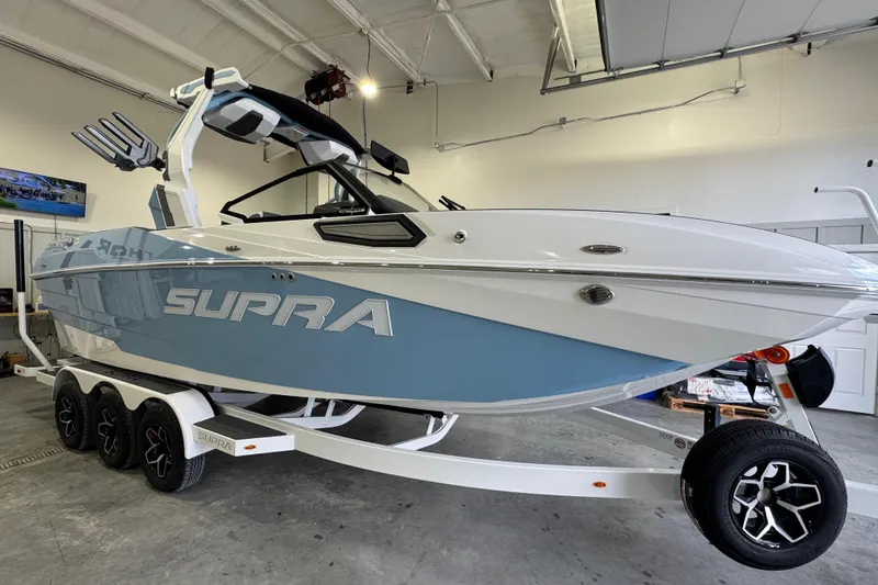 Slide: The Image of 2026 Supra SE boat in showroom, featuring sleek design and modern trailer. - 9