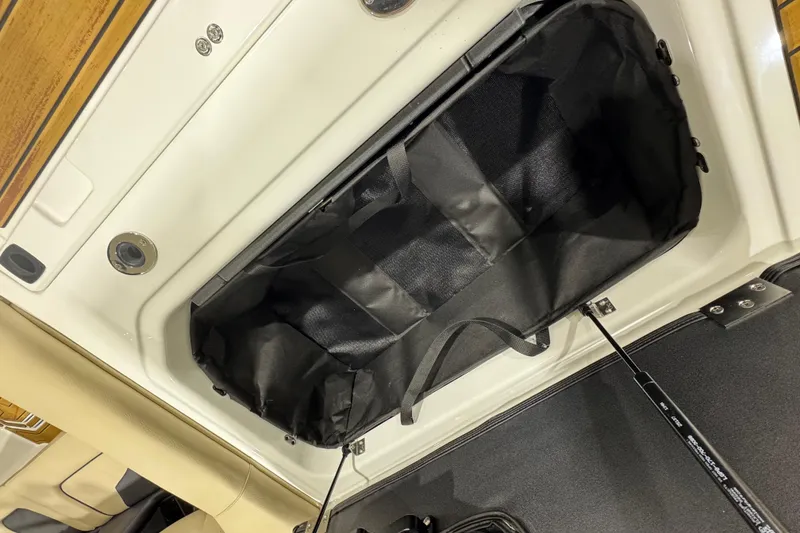 Slide: The Image of 2026 Moomba Mojo boat storage compartment with black interior lining and hydraulic lift support. - 10