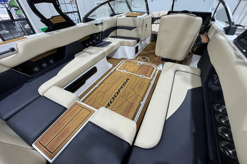 Slide: The Image of 2026 Moomba Mojo boat interior with beige and black seating, wood accents, and modern design. - 11