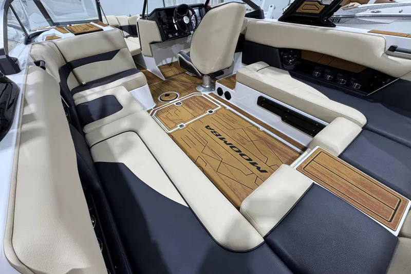 Slide: The Image of 2026 Moomba Mojo boat interior with beige and black seating, wood accents, and modern design. - 12