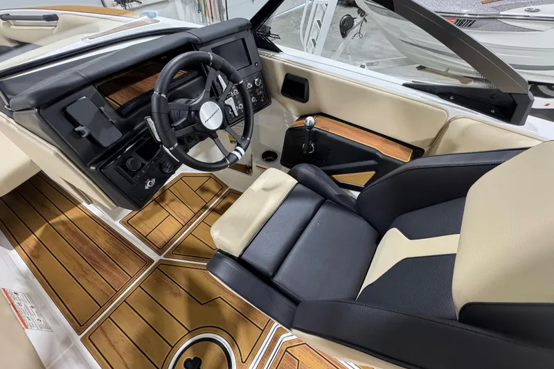 Slide: The Image of 2026 Moomba Mojo boat interior with sleek dashboard, steering wheel, and wood-accented flooring. - 15