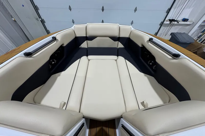 Slide: The Image of 2026 Moomba Mojo boat interior with beige and navy seating in a garage setting. - 18