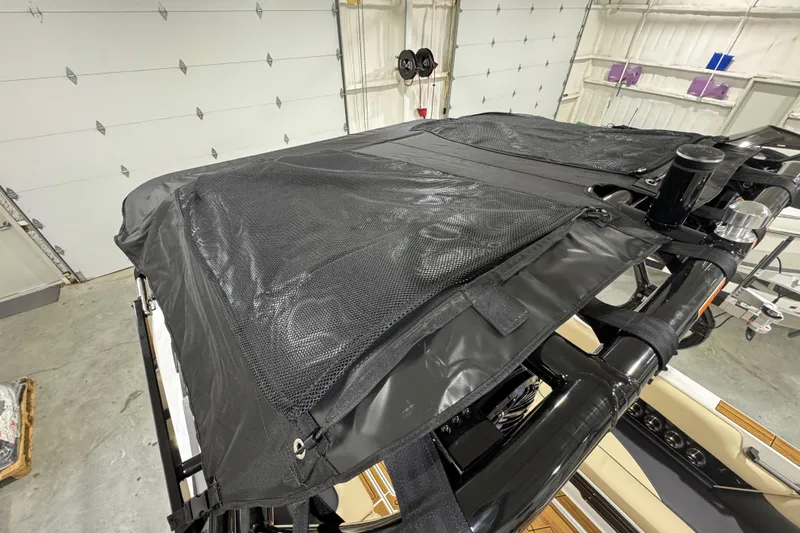 Slide: The Image of 2026 Moomba Mojo boat with black mesh cover in a garage setting. - 20