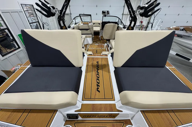 Slide: The Image of 2026 Moomba Mojo boat interior with stylish seating and wood accents in a garage setting. - 9