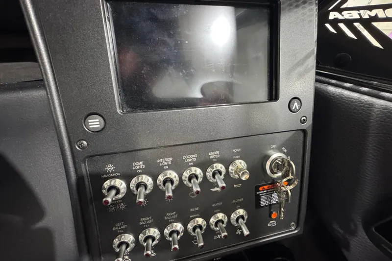 Slide: The Image of Control panel of a 2026 Moomba Max boat with switches and ignition key. - 13