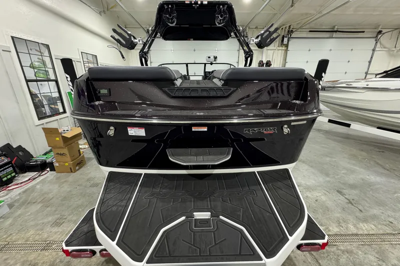 Slide: The Image of 2026 Moomba Max boat rear view in a showroom, featuring Raptor engine branding. - 3