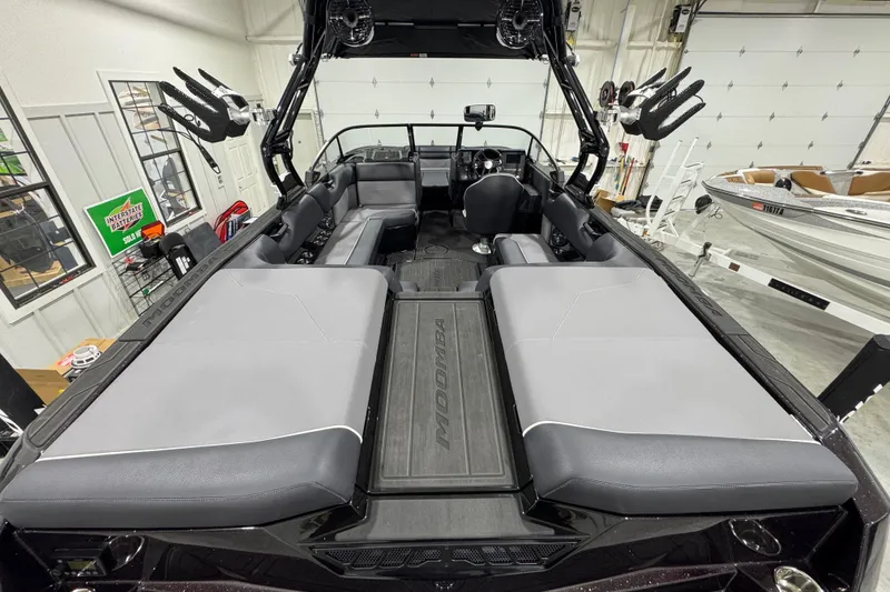 Slide: The Image of 2026 Moomba Max boat interior with spacious seating and modern design in a garage setting. - 8