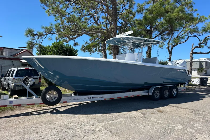 The Image of 2026 Contender 35 ST boat on trailer, parked outdoors under clear blue sky. - 0