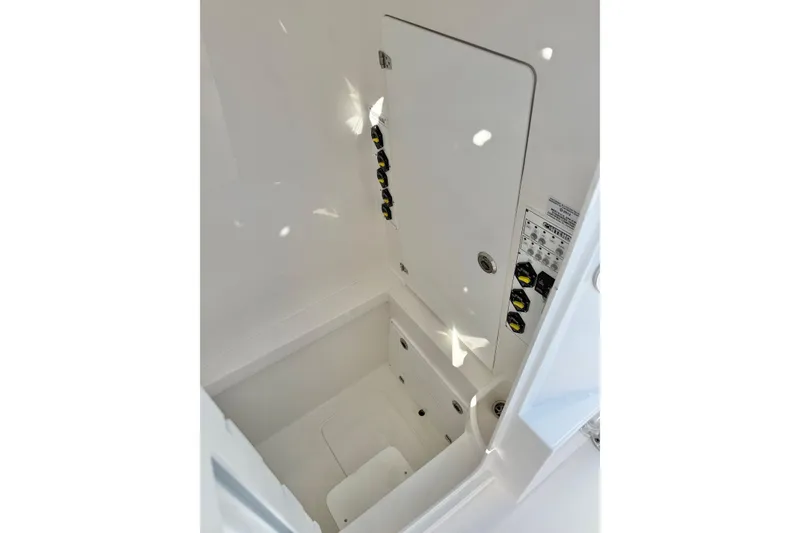 Slide: The Image of Interior compartment of 2026 Contender 35 ST boat, featuring storage and control panel. - 16