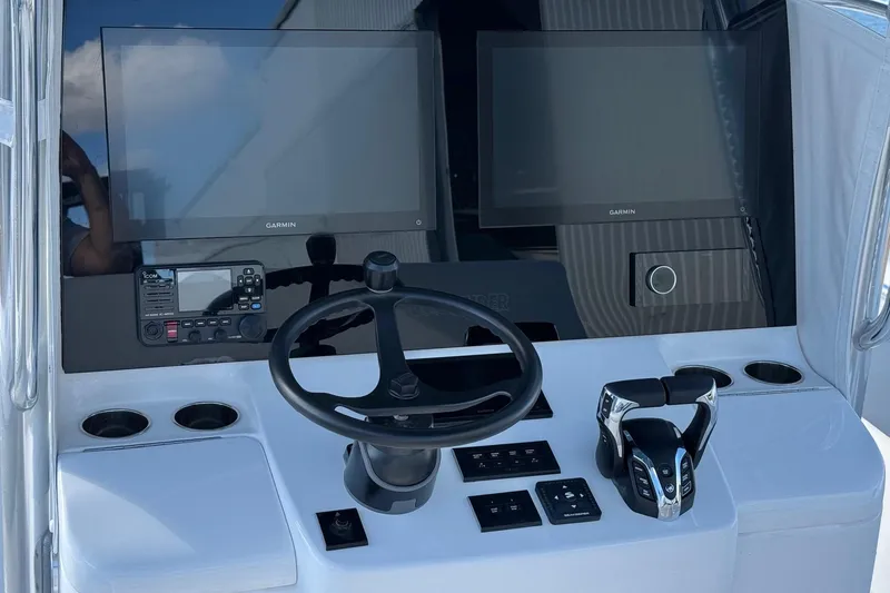 Slide: The Image of 2026 Contender 35 ST boat dashboard with Garmin displays and steering wheel. - 7