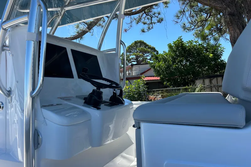 Slide: The Image of 2026 Contender 35 ST boat cockpit with steering wheel and dual screens, surrounded by trees. - 8