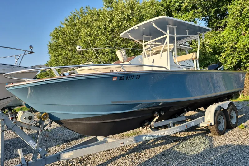 Slide: The Image of 1977 Wellcraft 270 Coastal O/B boat on trailer, surrounded by greenery. - 15