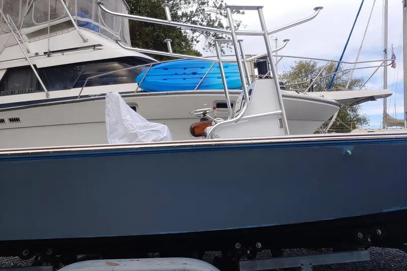 Slide: The Image of 1977 Wellcraft 270 Coastal O/B boat on trailer, docked with other vessels. - 5