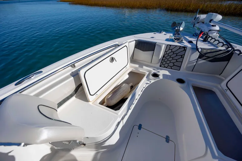 Slide: The Image of 2019 Wellcraft 222 Fisherman boat interior with open storage compartment on calm water. - 10