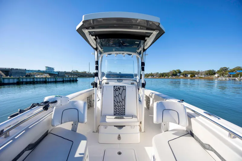 Slide: The Image of 2019 Wellcraft 222 Fisherman boat on calm water, clear sky, and scenic background. - 12