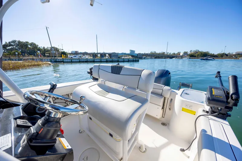 Slide: The Image of 2019 Wellcraft 222 Fisherman boat interior with steering wheel, seating, and water view. - 14