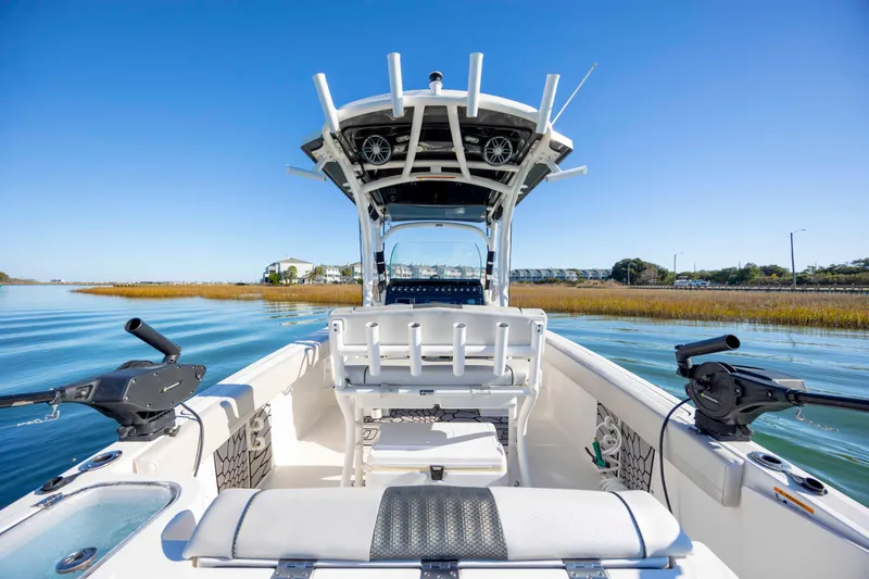 Slide: The Image of 2019 Wellcraft 222 Fisherman boat on calm water, featuring fishing equipment and seating. - 23