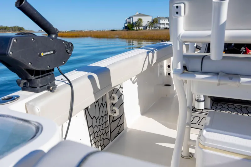Slide: The Image of 2019 Wellcraft 222 Fisherman boat interior with fishing equipment on a sunny day. - 24