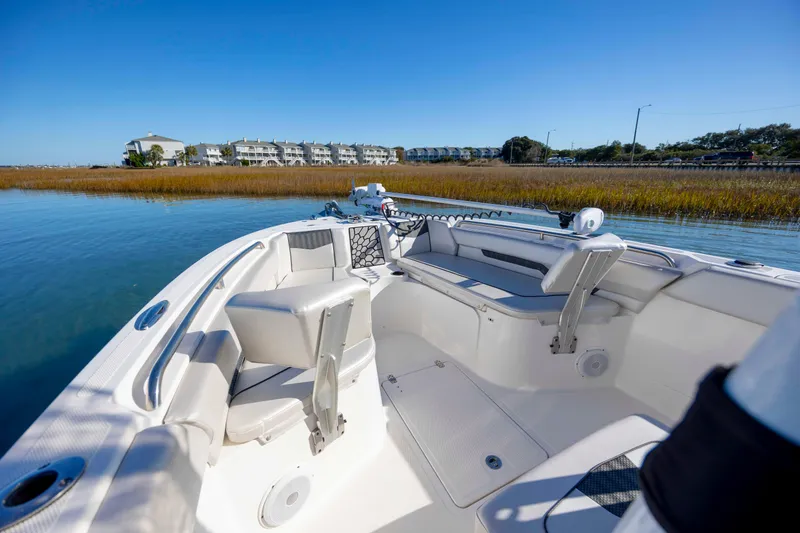 Slide: The Image of 2019 Wellcraft 222 Fisherman boat interior on calm water, with scenic shoreline view. - 8