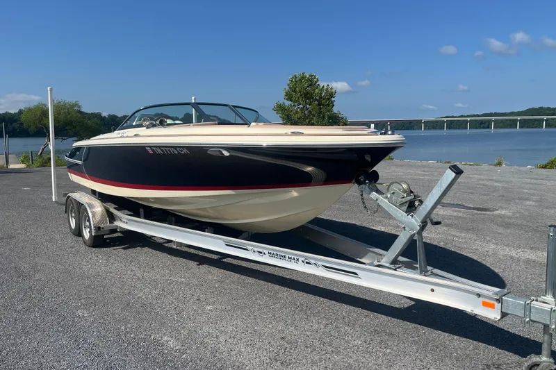 The Image of 2018 Chris-Craft Launch 23 boat on trailer by a scenic lake. - 0