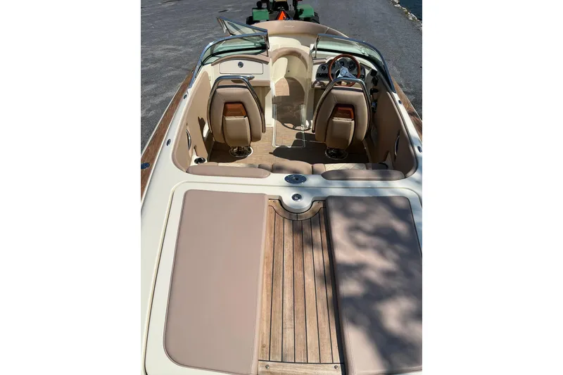Slide: The Image of 2018 Chris-Craft Launch 23 boat interior with tan seating and wooden deck. - 6