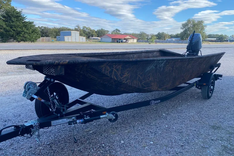 Slide: The Image of 2026 G3 Gator Tough 17 DK boat on trailer, camo design, outdoor setting. - 2