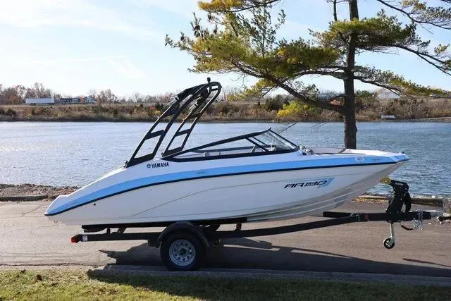 The Image of 2026 Yamaha Boats AR190 on trailer by a scenic riverside. - 0