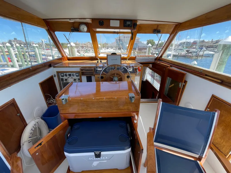 Slide: The Image of 1970 Matthews Flush Deck Cruiser helm with wooden dashboard and marina view. - 15