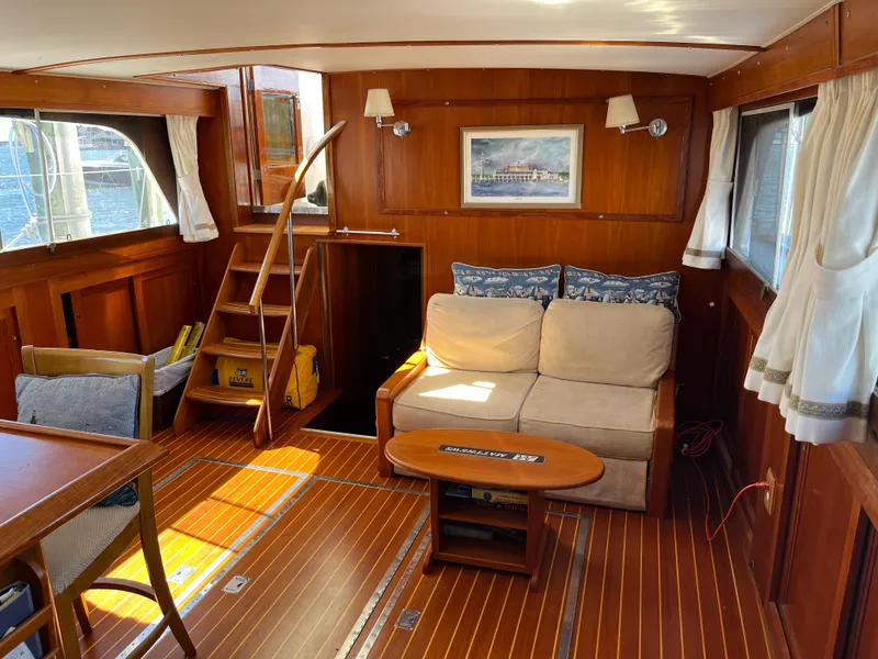 Slide: The Image of Interior of a 1970 Matthews Flush Deck Cruiser with wooden decor and cozy seating area. - 19