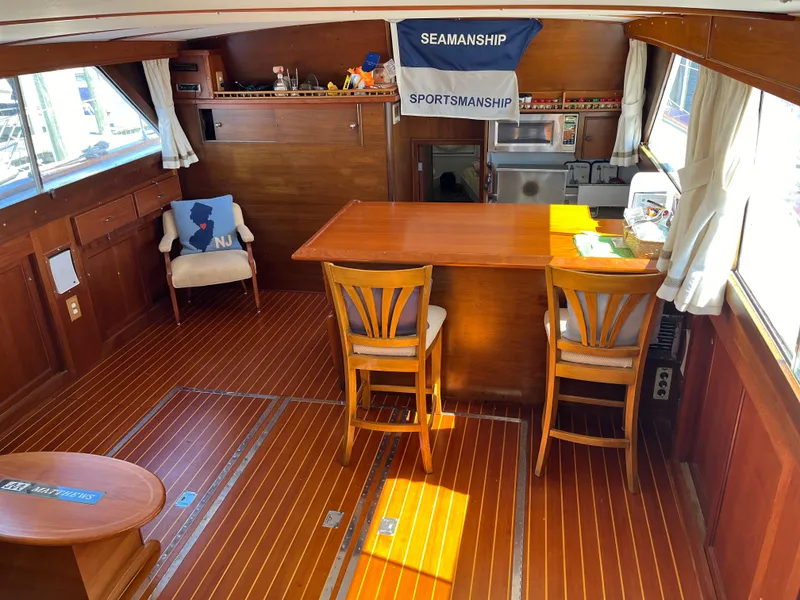 Slide: The Image of 1970 Matthews Flush Deck Cruiser interior with wooden flooring and dining area. - 21