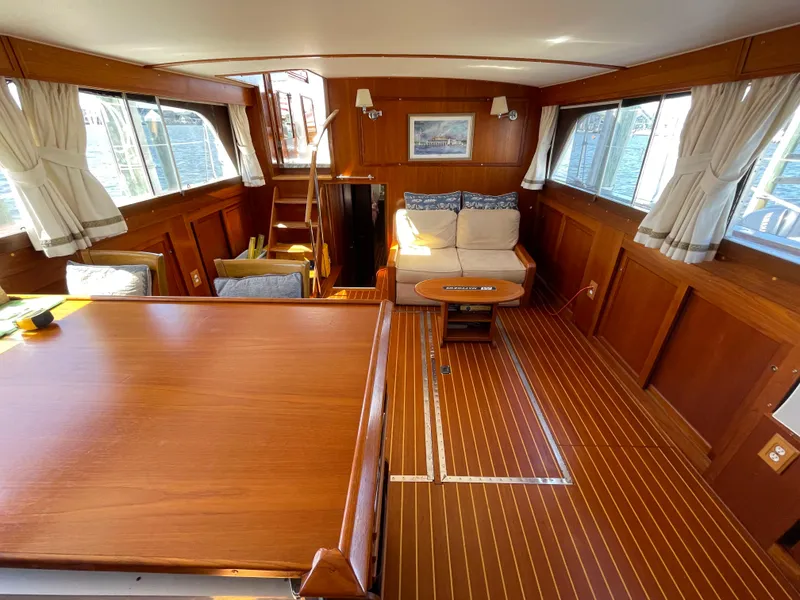 Slide: The Image of 1970 Matthews Flush Deck Cruiser interior with wood paneling and seating area. - 23