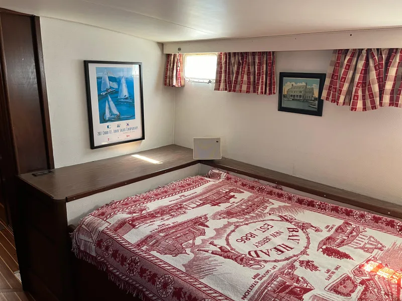 Slide: The Image of 1970 Matthews Flush Deck Cruiser interior with nautical decor and patterned bedspread. - 29